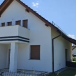 otynkowany budynek w białym kolorze z pasami z czarnego tynku